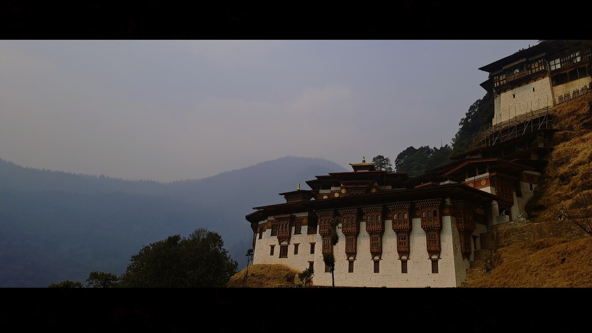 A Bhutanese dzong rising above a misty valley